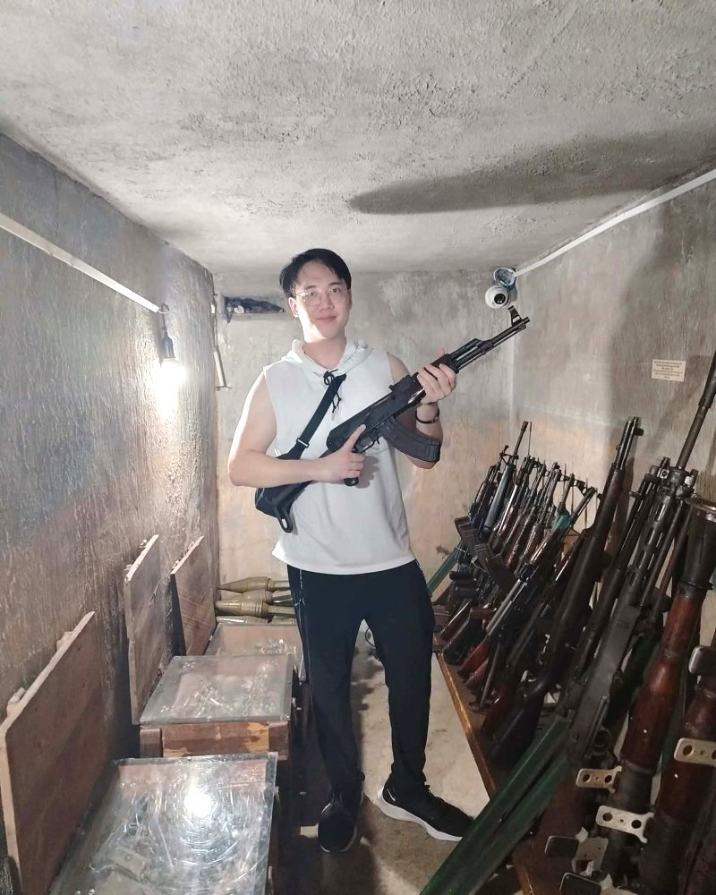 A guest at the Cu Chi Tunnels weapons room on a Vietnam Crazy Tour